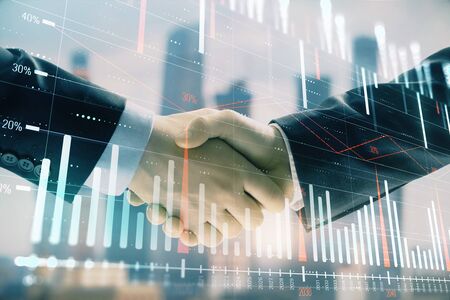 Double exposure of financial graph on cityscape background with two businessman handshake. Concept of stock market dealの写真素材