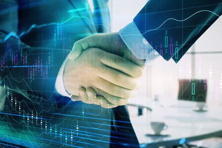 Multi exposure of financial graph on office background with two businessmen handshake. Concept of success in businessの写真素材