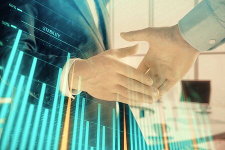 Multi exposure of financial graph on office background with two businessmen handshake. Concept of success in businessの写真素材