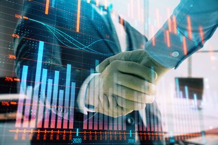 Multi exposure of financial graph on office background with two businessmen handshake. Concept of success in businessの写真素材