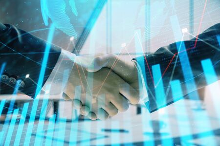 Multi exposure of financial chart and map on office background with two businessmen handshake. Concept of success in businessの写真素材