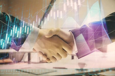 Multi exposure of financial graph on office background with two businessmen handshake. Concept of success in businessの写真素材