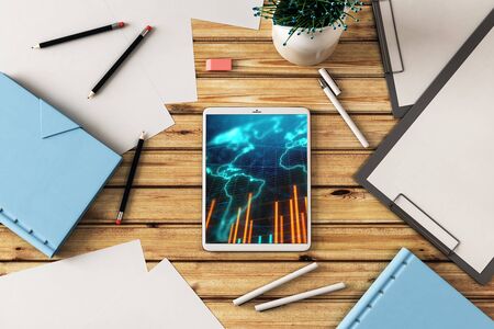 Digital tablet closeup top view with financial graph and partial world map on screen. Online international trading application concept. 3d rendering.の写真素材