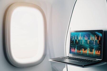 Laptop closeup inside airplane with forex graph on screen. Financial market trading concept. 3d rendering.の写真素材
