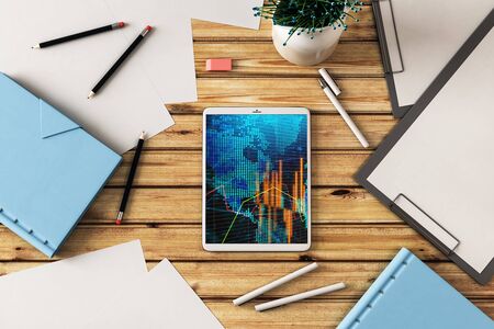Digital tablet closeup top view with financial graph and partial world map on screen. Online international trading application concept. 3d rendering.の写真素材