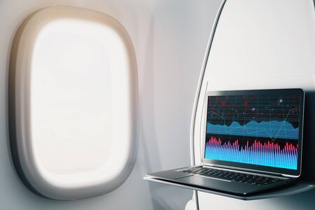 Laptop closeup inside airplane with forex graph on screen. Financial market trading concept. 3d rendering.の写真素材