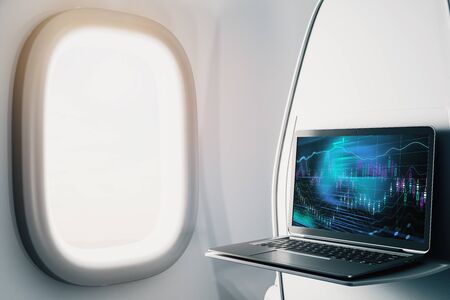 Laptop closeup inside airplane with forex graph on screen. Financial market trading concept. 3d rendering.の写真素材