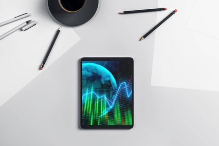 Digital tablet closeup top view with financial graph and partial world map on screen. Online international trading application concept. 3d rendering.の写真素材