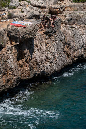 young people jumping into the water, Cala Beltran, Llucmajor, Mallorca, Balearic Islands, Spainのeditorial素材