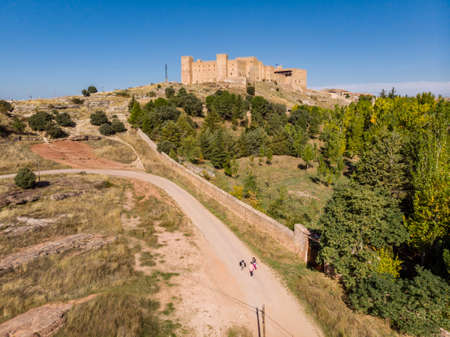 three people on a road, SigÃ¼enza Castle, 11th century, Siguenza, Guadalajara, Spainのeditorial素材