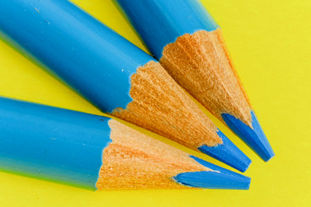 Blue colored pencils on yellow background
