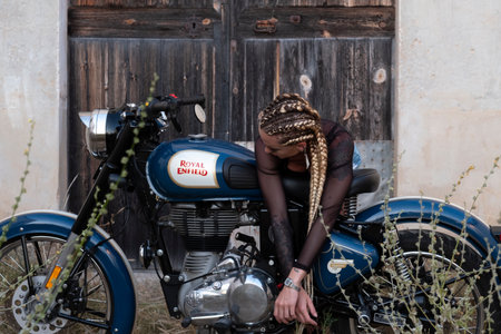 girl and Royal Enfield 500 motorbike, balearic islandsの写真素材