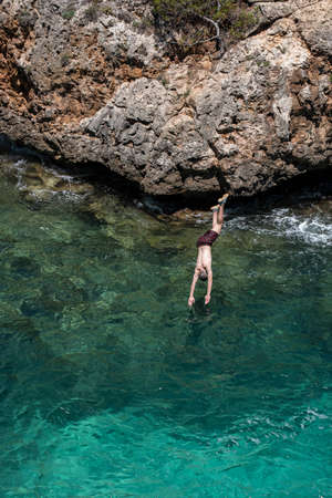 young people jumping into the water, Cala Beltran, Llucmajor, Mallorca, Balearic Islands, Spainの写真素材