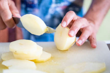 cutting potatoes to cook moussaka, mallorca, spainの写真素材