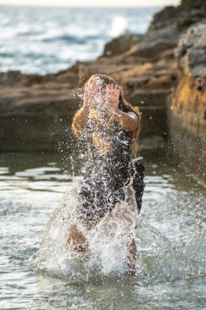 middle-aged woman dancing and throwing water in the air, Maioris beach, llucmajor, Majorca, Balearic...