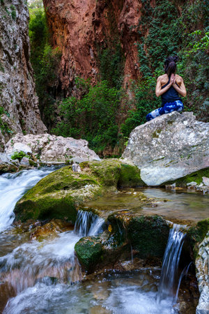 woman practicing yoga by the river, God's Bridge, Akchour, Talassemtane Nature Park, Rif region, morocco, africaの写真素材