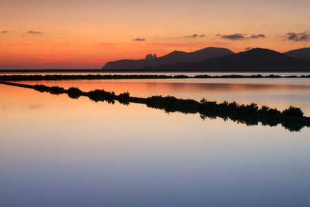 Sunset in the lagoon with mountains in the background and reflectionの写真素材