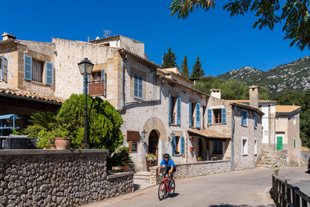 cyclist crossing Orient village, Bunyola, Majorca, Balearic Islands, Spain