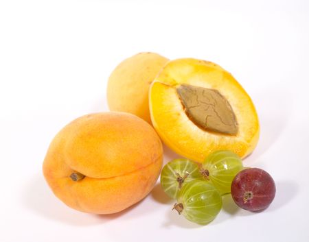 Few apricots and goosberries on bright background with shadow. Is not isolated imageの写真素材