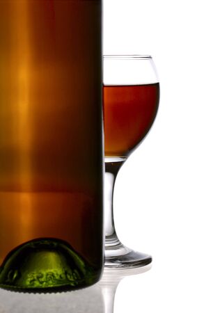 wine bottle with half of wineglass ovr white. not isolatedの写真素材