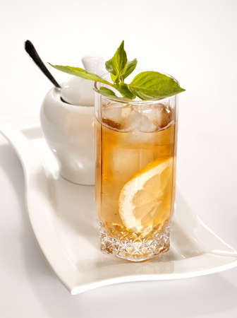 glass of cold green tea with ice, mint  and lemon on the plateの写真素材