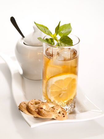 glass of cold green tea with ice, mint  and lemon on the plateの写真素材