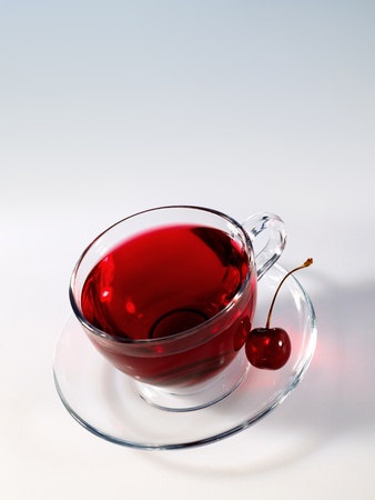 hibiscus herbal tea in glass cup with ripe tasty cherryの写真素材