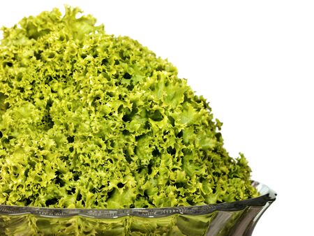 green fresh salad leaves in the glass bowl, over white backgroundの写真素材