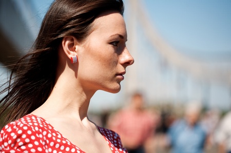Beauty young woman on the bridge with unfocused people on backgroundの写真素材