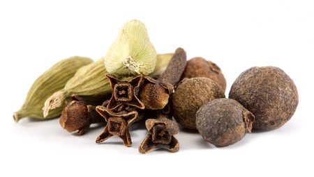 closeup of cloves, cardamon and allspice over white backgroundの写真素材