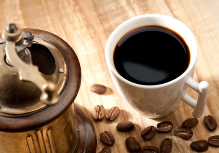 Coffee still-life with cup and mill over wooden deskの写真素材