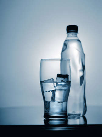 glass of cold mineral water with ice and plastic bottle  scanned from 6x7 filmの写真素材