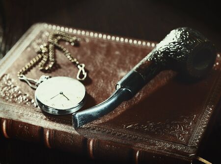 Abstract retro still life with old leather covered book and watchの写真素材
