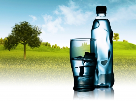Spring mineral water bottled with glass and ice against natural landscapeの写真素材