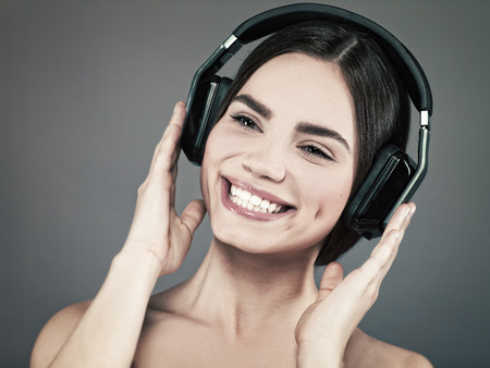 Beauty young girl hearing music with headset, female portraitの写真素材