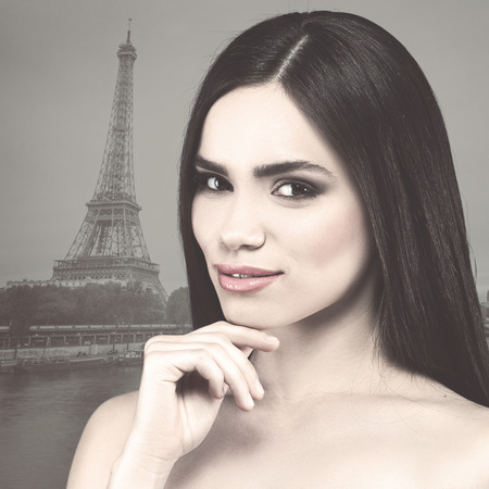 Retro female portrait. Young beauty against Eiffel Towerの写真素材