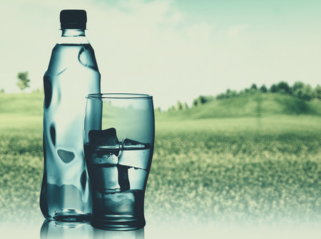 Bottled spring mineral water against abstract natural backgroundsの写真素材