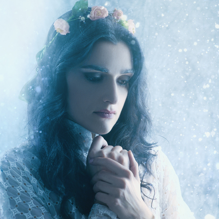 Snow queen, beauty female portrait with snowfall as backgroundsの写真素材