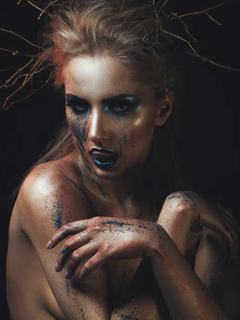 Forest soul. Wild female portrait with art makeup, low key styleの写真素材