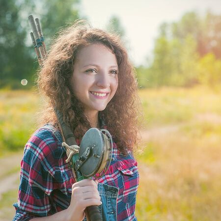 Fisher woman with wintage fishing pole, walking to the summer river, relaxation and leisure backgroundsの写真素材