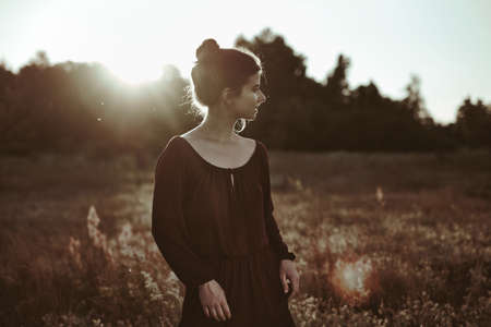 Summer Portrait. Young adult woman walking around meadowの写真素材
