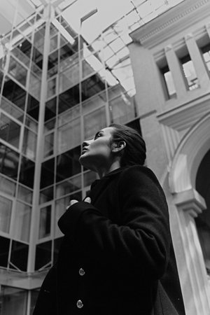Looking up, Female portrait with city architecture as background. Film grain addedの写真素材