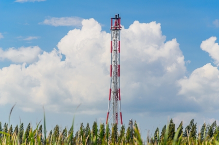 Refinery flare with the grass foreground and blue sky backgroundの写真素材