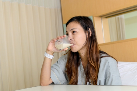 Lady patient drink a glass of milk in hospitalの写真素材