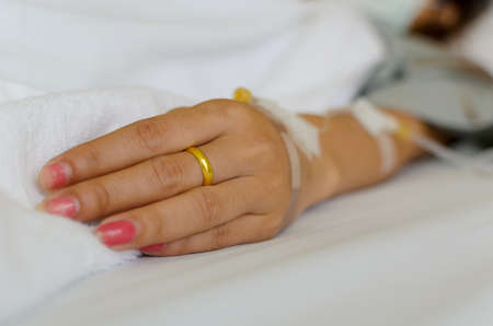 Close up of young lady patient hand recovering in hospitalの写真素材