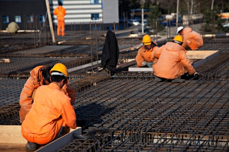 Builders doing construction work. They work on steel structures and fixtures