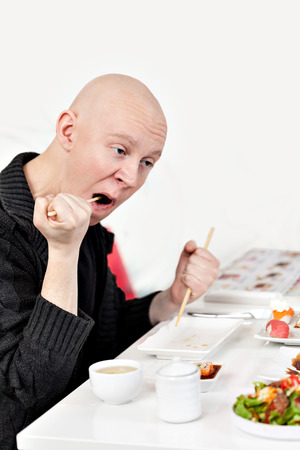 Crasy man cleans his teeth with big sticksの写真素材