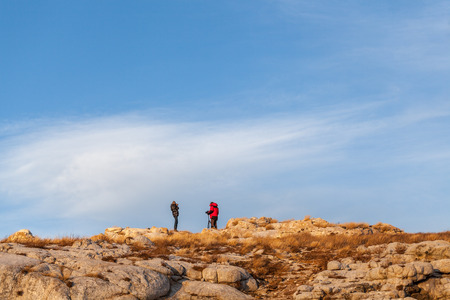 Two photographers are taking picture on stone hillの写真素材