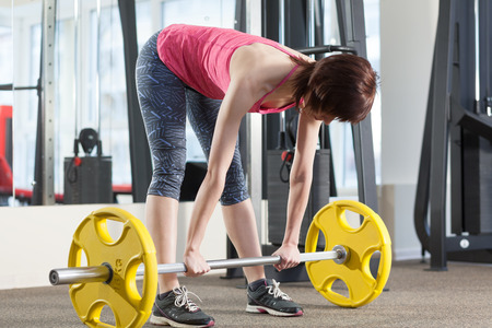Woman preparing to exercise with barbellの写真素材