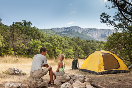 Father with little son in the summer camping on a meadowの写真素材